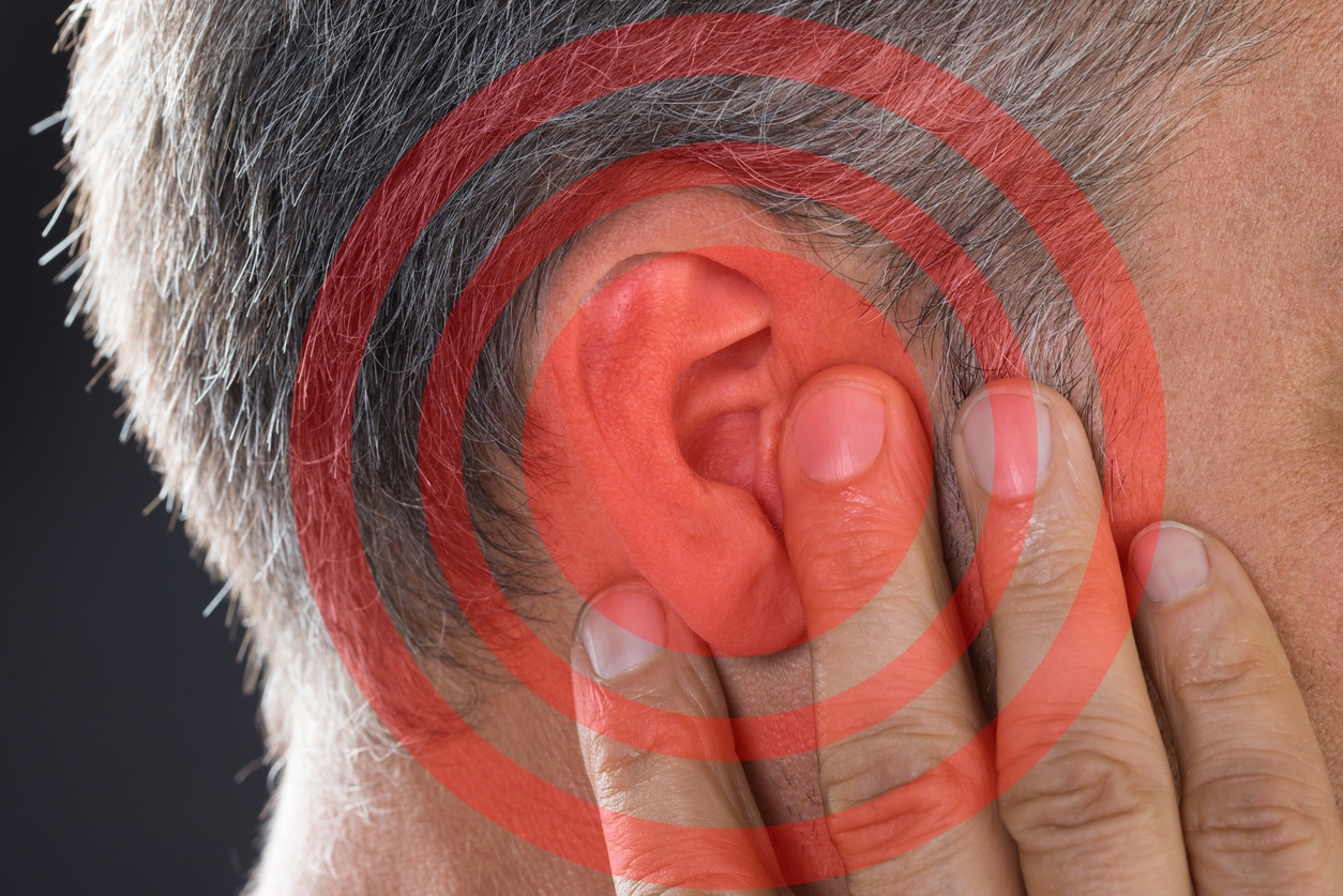 Man holding his hand against his ear  because of ear pain