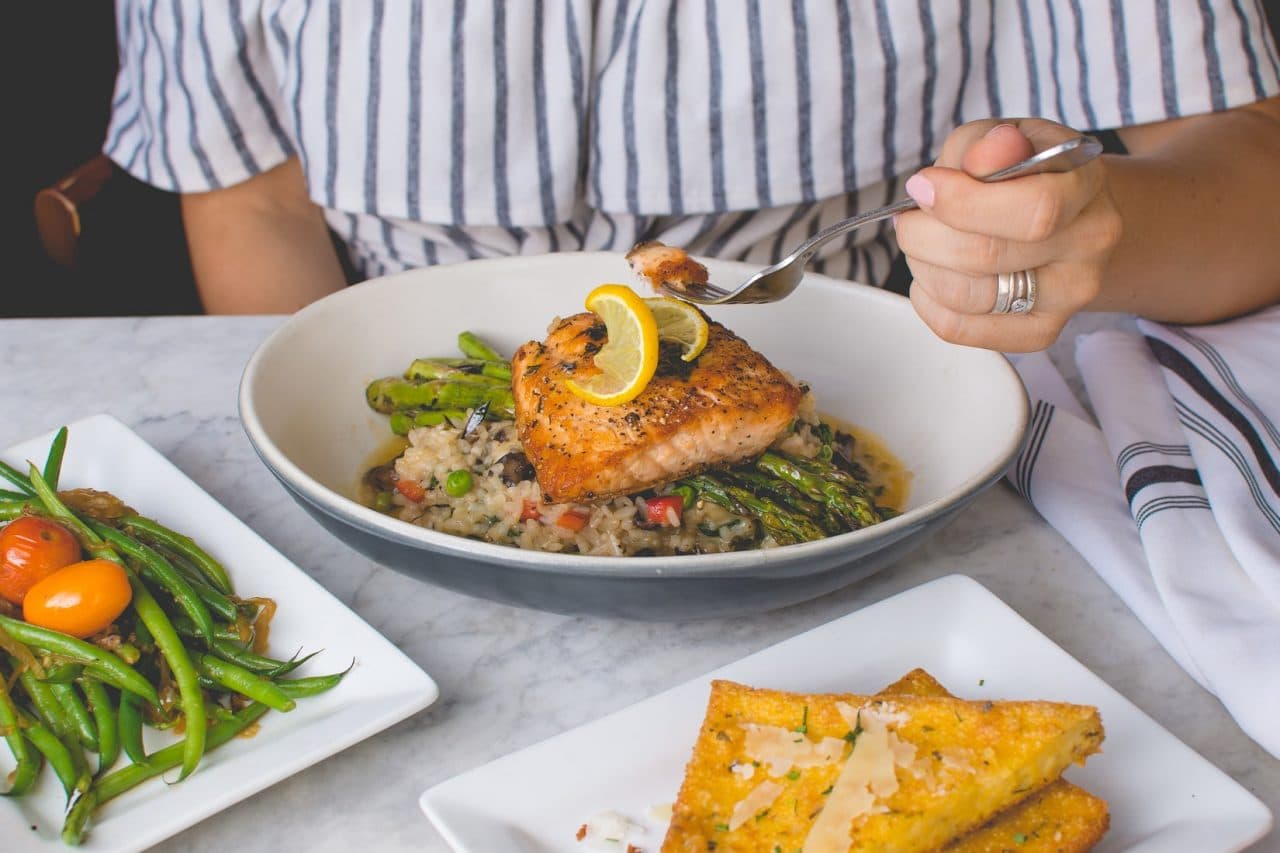 Grilled fish fillet on a plate with vegetables.