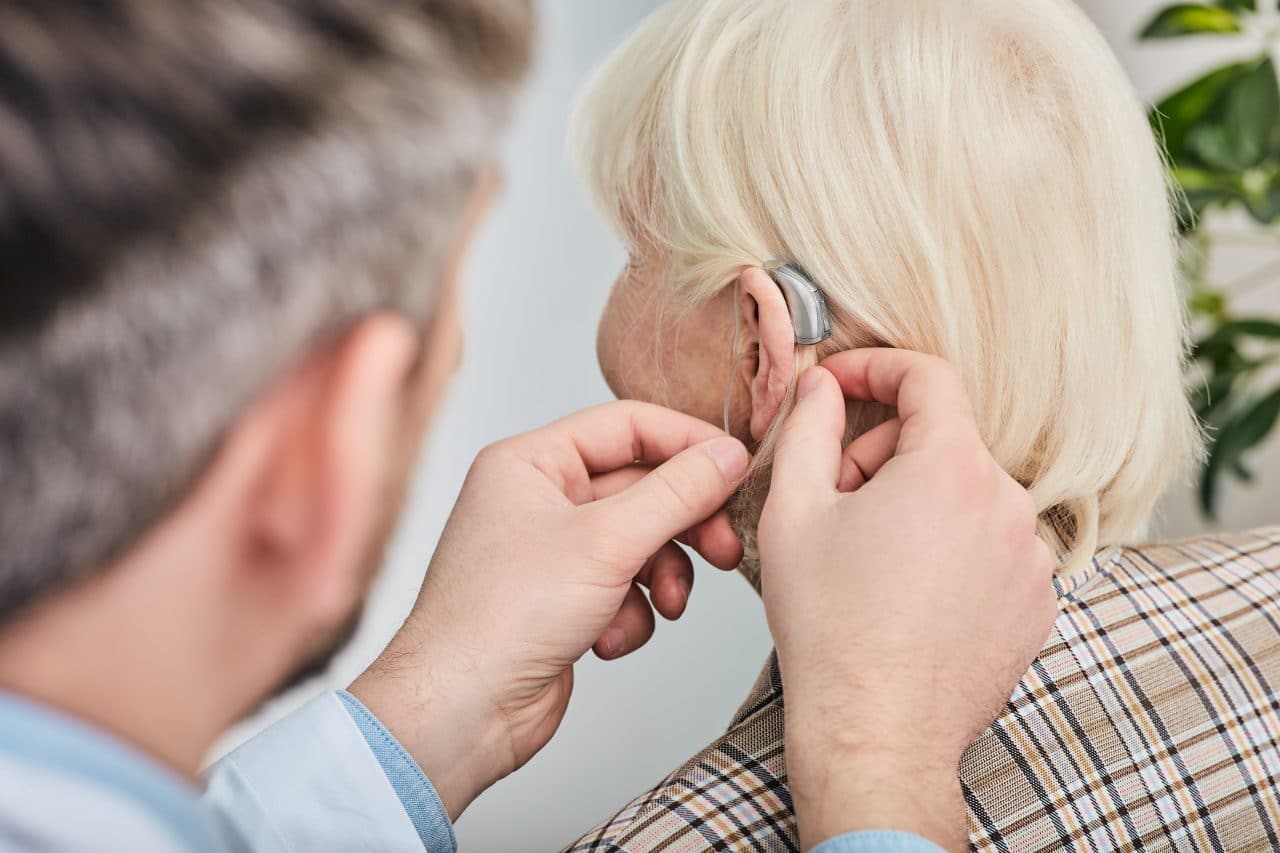 A woman getting her hearing aids adjusted by an audiologist.