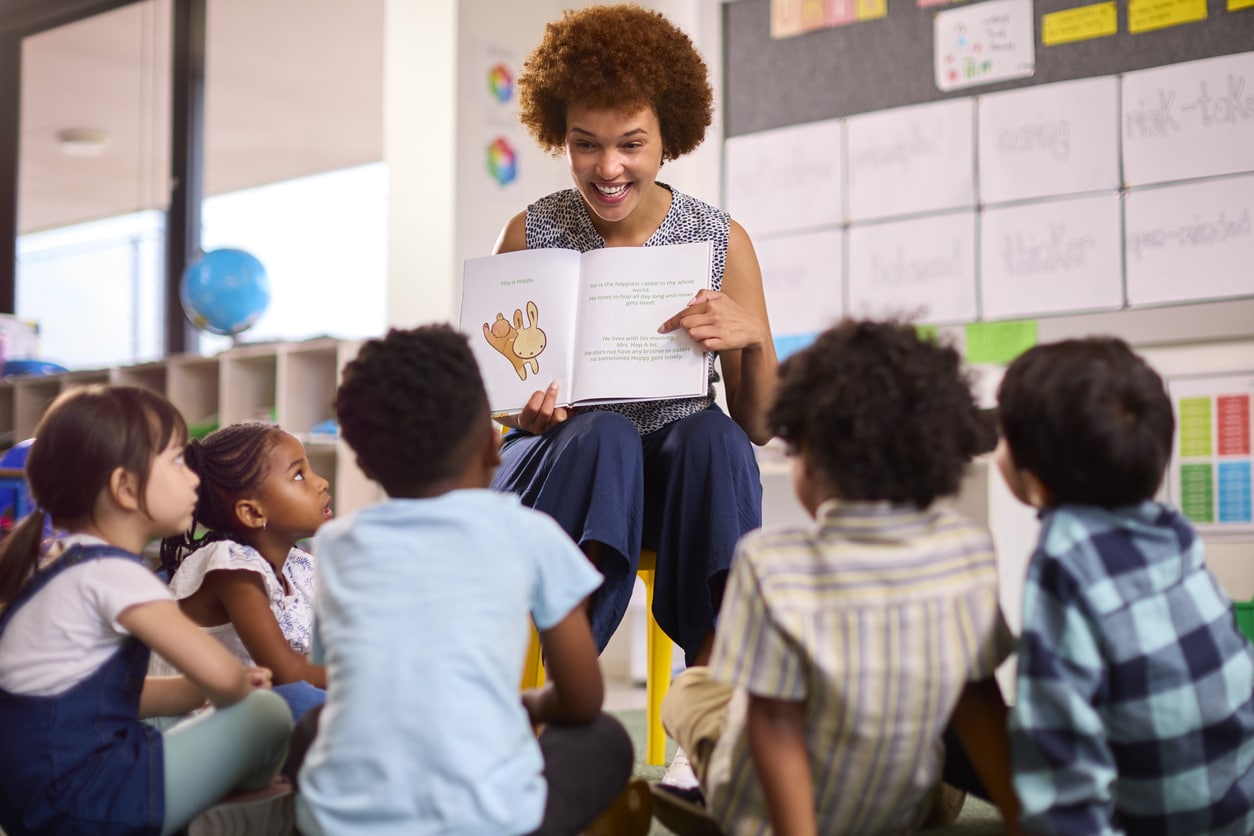 Teacher reading to a group of school children.