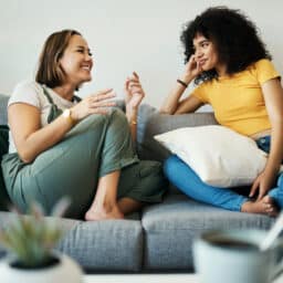 Two women talking on a couch